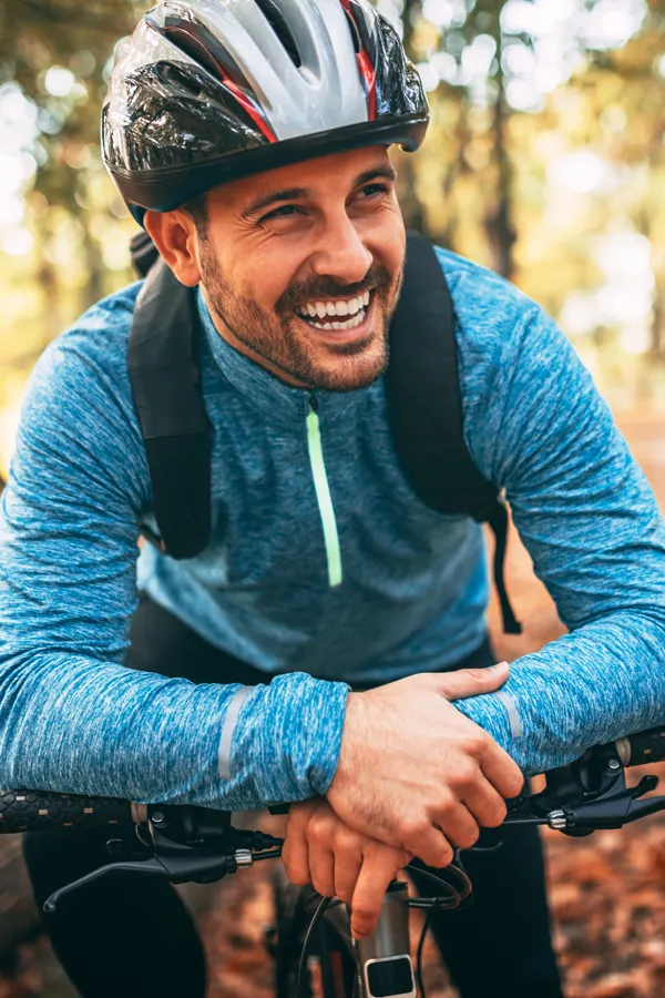 Adrenal-Hormone-Disorder-Treatment A smiling man getting ready for a cycling trip. Get treatment for adrenal hormone disorder from Thrive Family Practice & Med Spa in Statesboro.