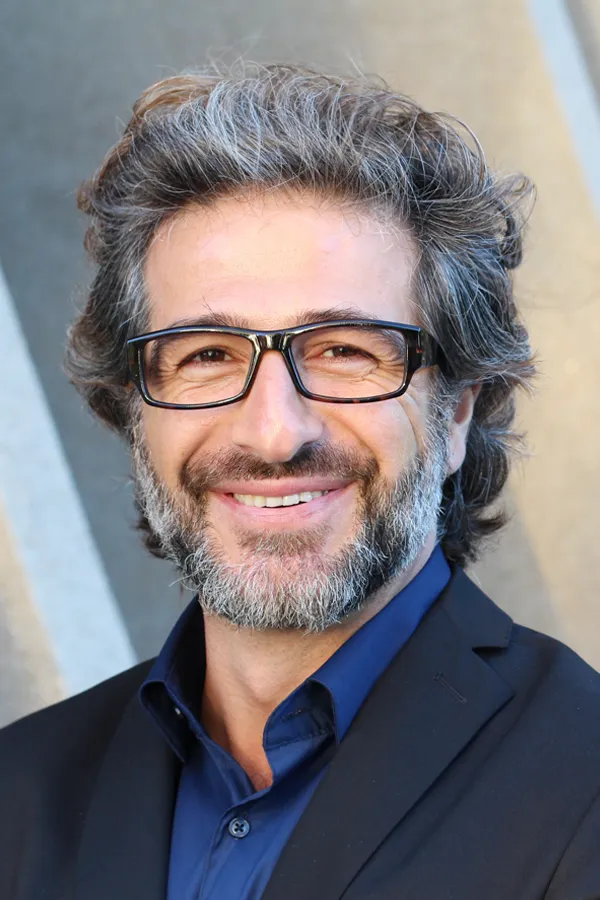 Andropause-and-Low-Testosterone-Treatment A man with glasses, salt and pepper hair and a beard smiling because he received treatment for andropause and low testosterone from Thrive Family Practice & Med Spa in Statesboro.