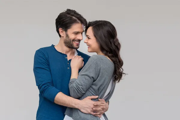 Erectile-Dysfunction-Doctor A man in a blue shirt embracing a woman in a gray shirt smiles due to his successful erectile dysfunction care from Thrive Family Practice & Med Spa in Statesboro.