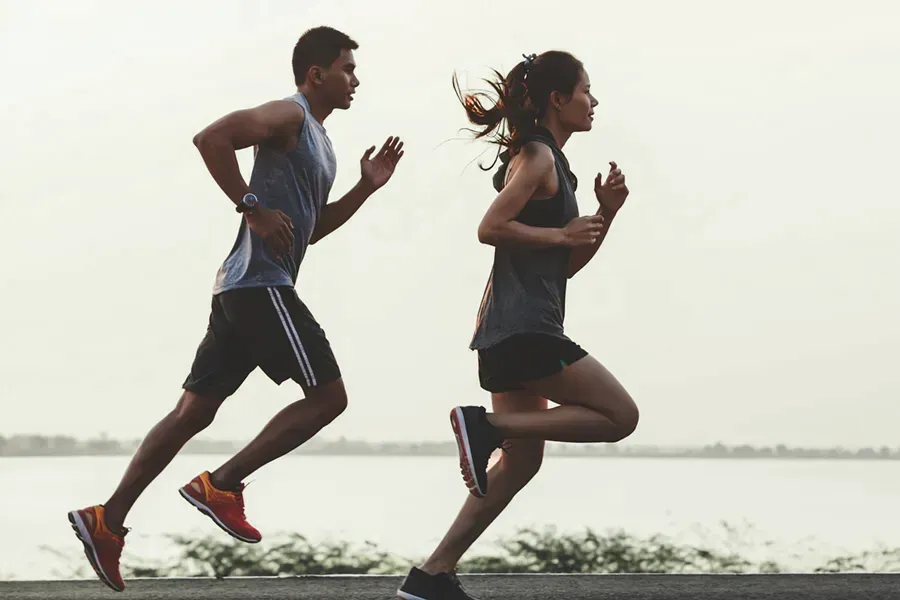 A couple in profile running along the water. Schedule GLP-1 Weight Loss Injections from Thrive Family Practice & Med Spa in Statesboro.