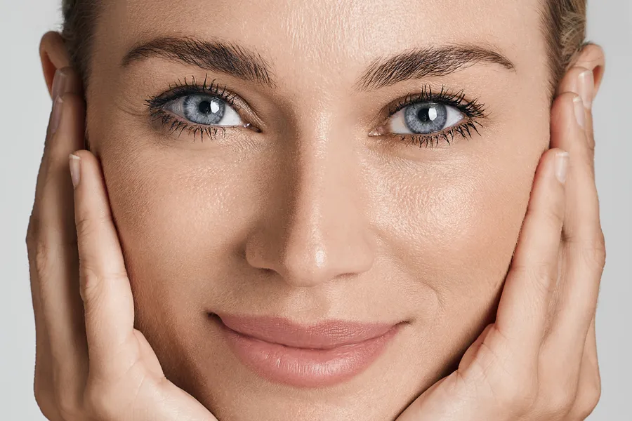 Glo2Facial-Clinic Close-up of a woman with beautiful skin holding her face. Get Glo2Facial treatment from Thrive Family Practice & Med Spa in Statesboro.