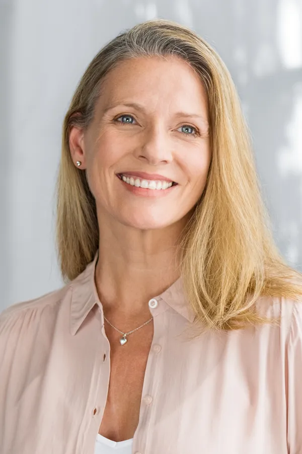 Glo2Facial-Treatment A middle-aged woman with long blonde hair smiles after a facial. Get Glo2Facial treatment from Thrive Family Practice & Med Spa in Statesboro.