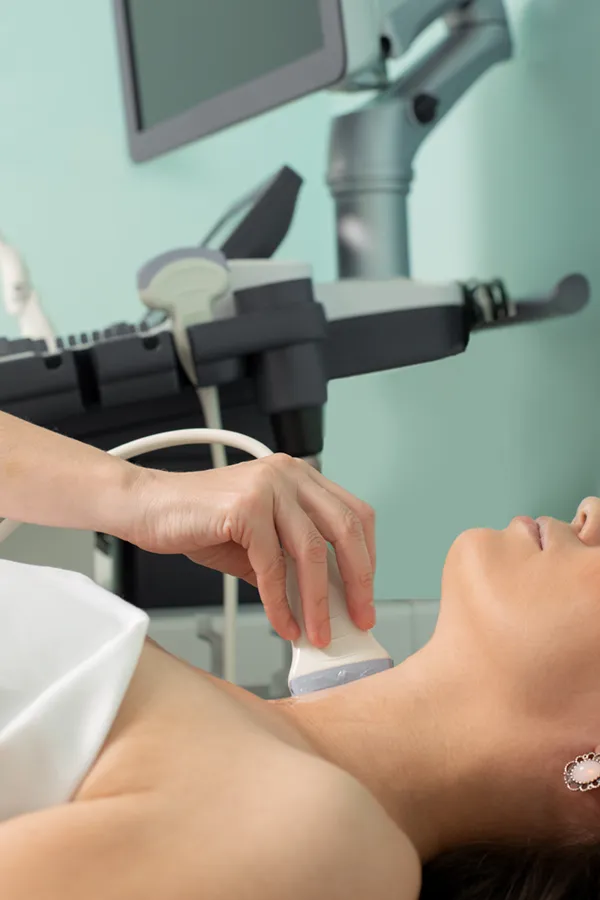 Hashimotos-Thyroiditis-Treatment A woman gets a thyroid scan from a doctor in a clinic. Get help with Hashimoto's Thyroiditis from Thrive Family Practice & Med Spa in Statesboro.