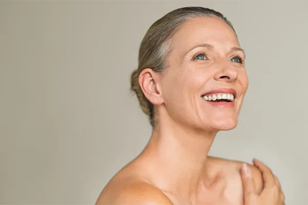 Liquid-Lipo-for-Face-Clinic An nude older woman with beautiful skin smiles. Get Liquid Lipo injections for facial rejuvenation from Thrive Family Practice & Med Spa in Statesboro.