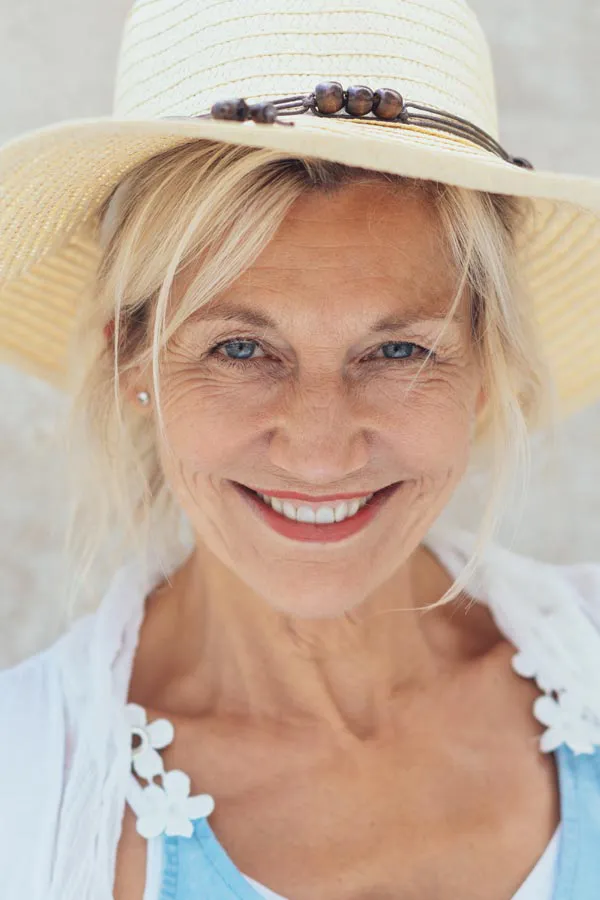 Menopause-Treatment A beautiful, smiling older woman with blonde hair and a sunhat, happy with menopause treatment from Thrive Family Practice & Med Spa in Statesboro.