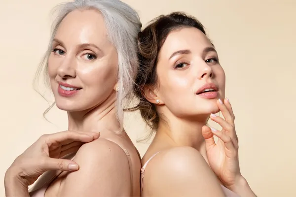 A mature woman with silver hair and a young woman both show their beautiful radiant skin. Get skincare solutions from Thrive Family Practice & Med Spa in Statesboro.