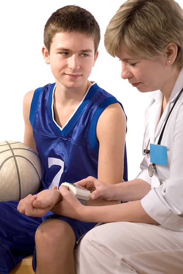 A middle-school aged child in basketball clothes gets a physical exam. Get sports physicals for children from Thrive Family Practice & Med Spa in Statesboro.