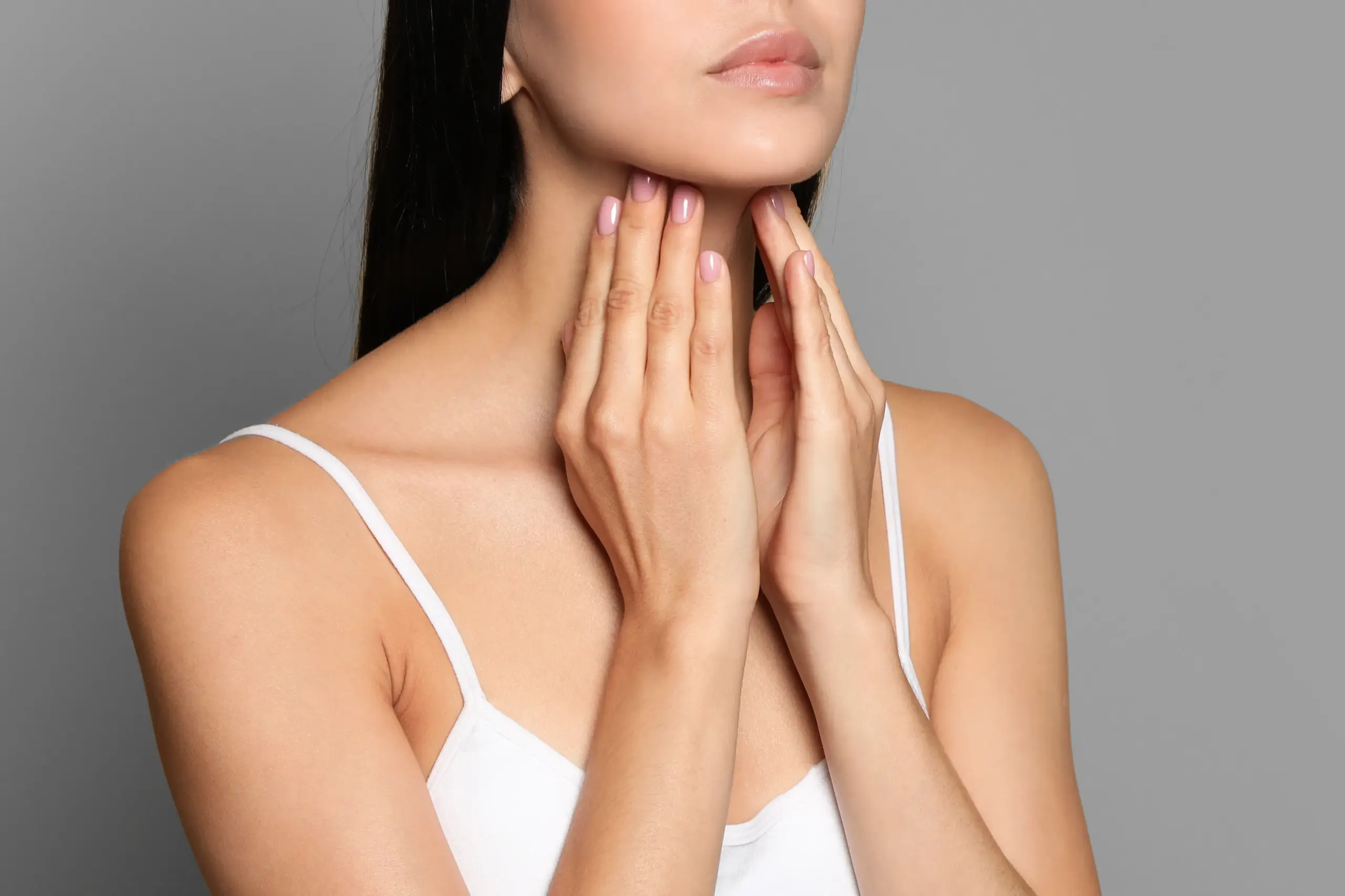 Thyroid-Doctor A woman in a white tank top touches her neck looking for signs of thyroid disorder. Get help for thyroid disorders from Thrive Family Practice & Med Spa in Statesboro.