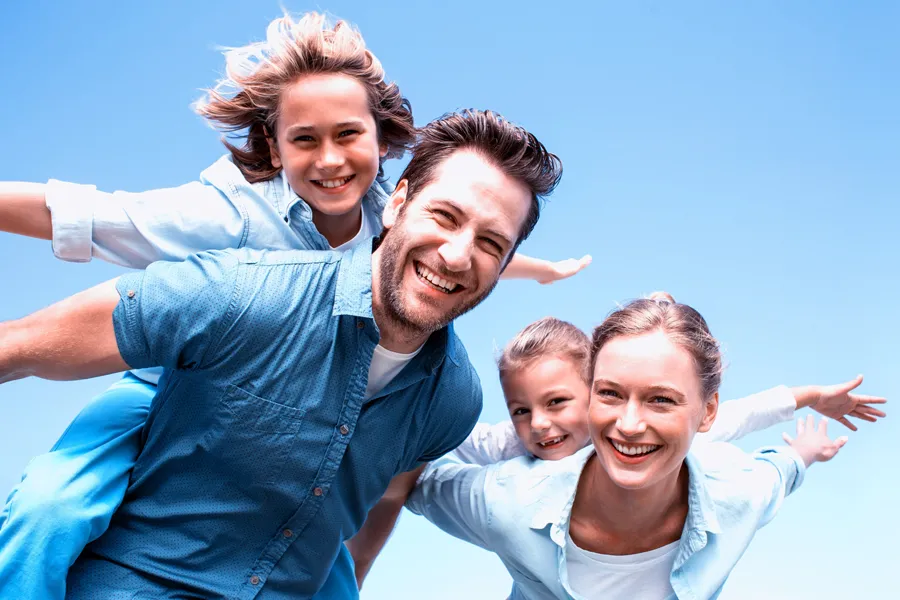 Whole-Family-Primary-Care-Clinic A family with outstretched arms playing under a blue sky. Get Whole Family Primary Care from Thrive Family Practice & Med Spa in Statesboro.